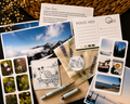 Collection of postcards, stationery items, and a pen on a textured surface.